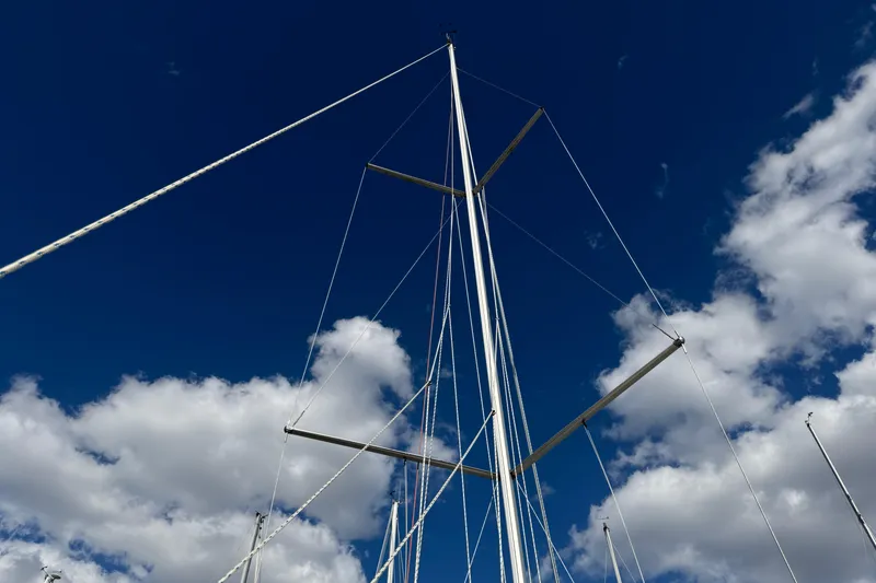 Slide: The Image of Mast of 2015 Jeanneau Sun Odyssey 349 sailboat against a blue sky with clouds. - 35