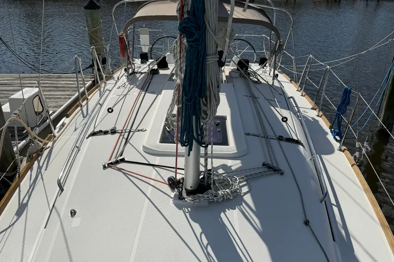 Slide: The Image of Deck view of a 2015 Jeanneau Sun Odyssey 349 sailboat docked by the water. - 37