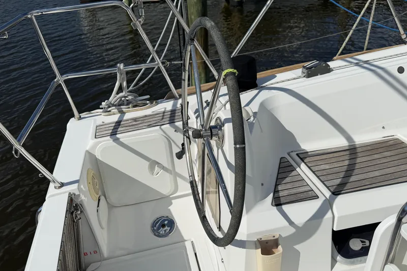 Slide: The Image of Steering wheel of a 2015 Jeanneau Sun Odyssey 349 sailboat, docked by the water. - 9
