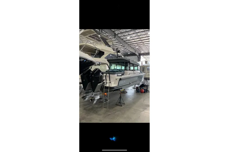 Slide: The Image of 2024 Axopar 37 XC Cross Cabin boat in a warehouse setting. - 11