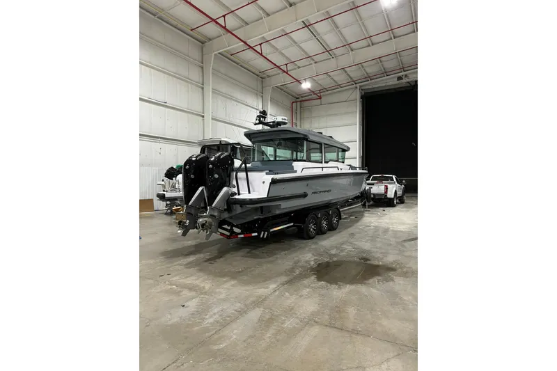 Slide: The Image of 2024 Axopar 37 XC Cross Cabin boat in a spacious indoor facility. - 4