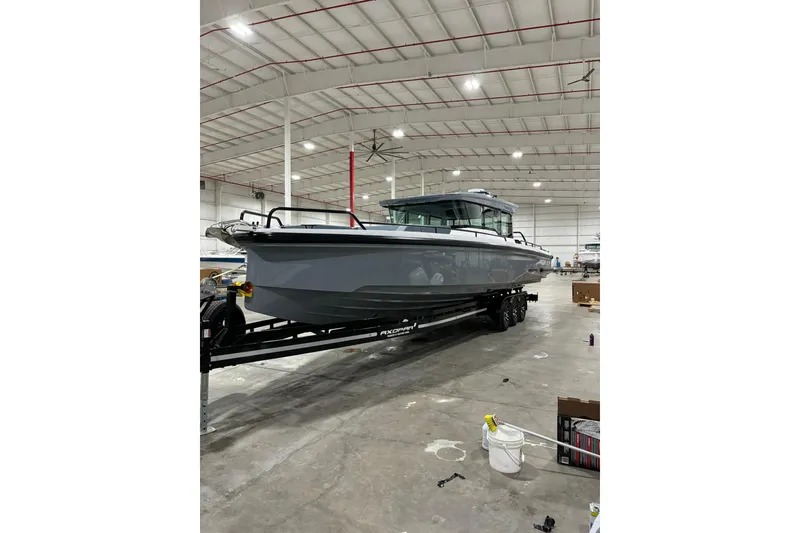Slide: The Image of 2024 Axopar 37 XC Cross Cabin boat on trailer in warehouse setting. - 6