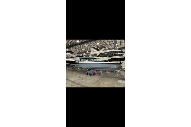 Slide: The Image of 2024 Axopar 37 XC Cross Cabin boat in a spacious indoor showroom. - 7