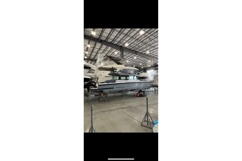 Slide: The Image of 2024 Axopar 37 XC Cross Cabin boat in a spacious indoor showroom. - 8