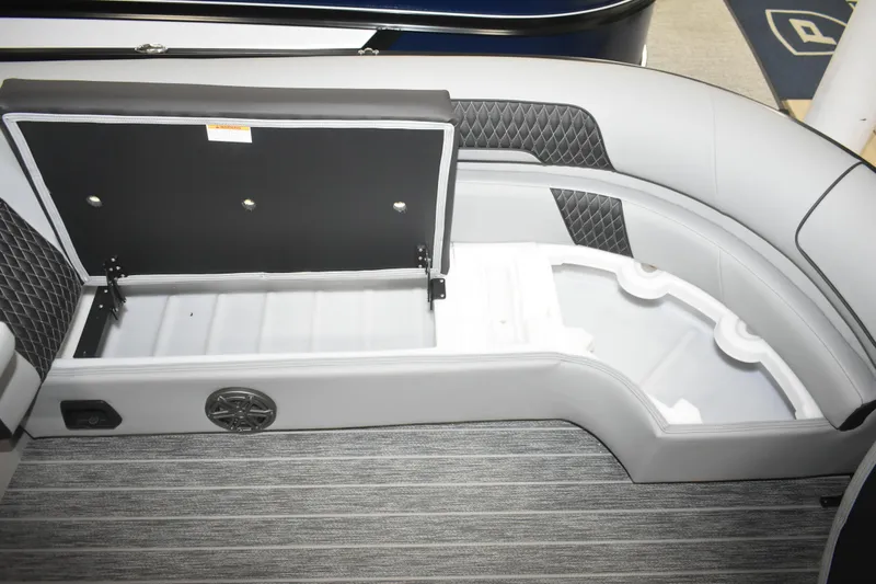 Slide: The Image of 2026 Premier 250 Solaris Sport boat interior storage compartment with open lid and speaker. - 19