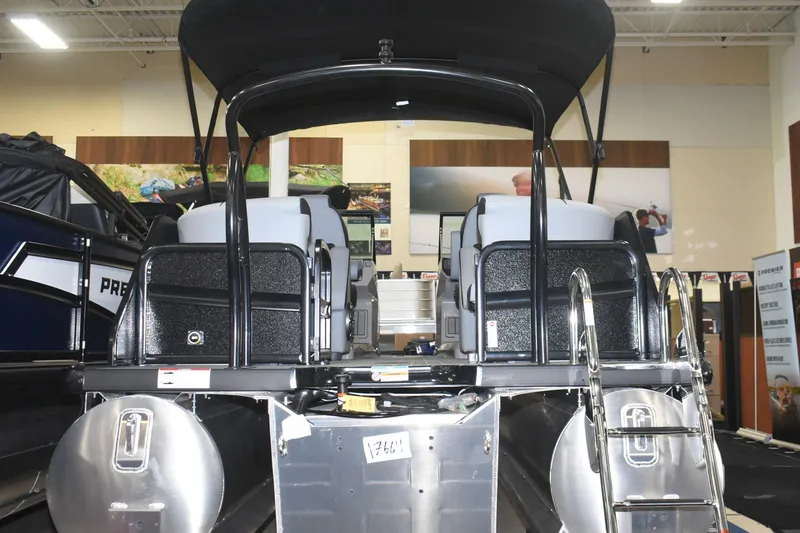 Slide: The Image of 2026 Premier 250 Solaris Sport pontoon boat displayed indoors, rear view with ladder. - 2