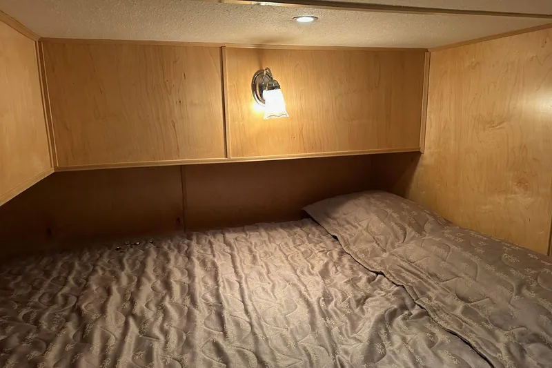 Slide: The Image of Cozy wooden interior of 2005 Starlite 16x82 with bed and wall light. - 10