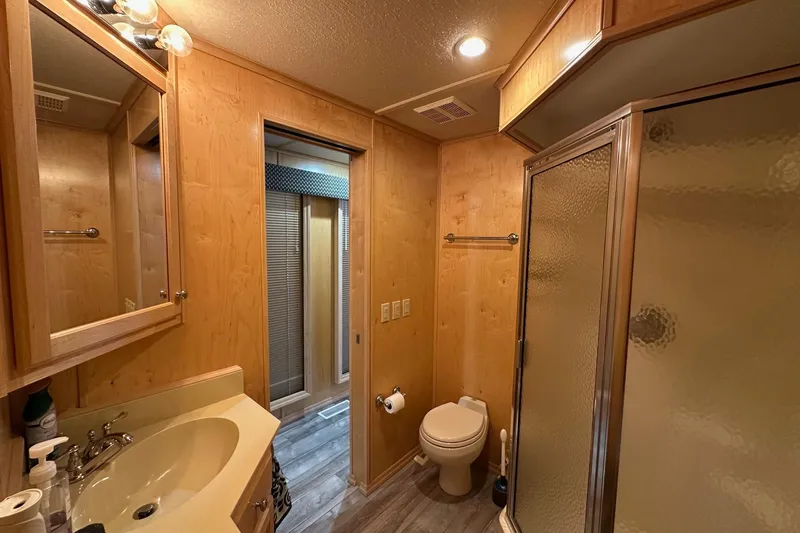 Slide: The Image of Bathroom in 2005 Starlite 16x82 with wood paneling, shower, and vanity. - 11