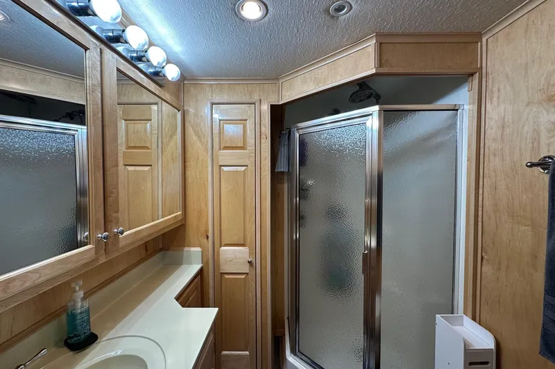 Slide: The Image of Luxurious bathroom in 2005 Starlite 16x82 houseboat with wooden cabinetry and glass shower. - 13