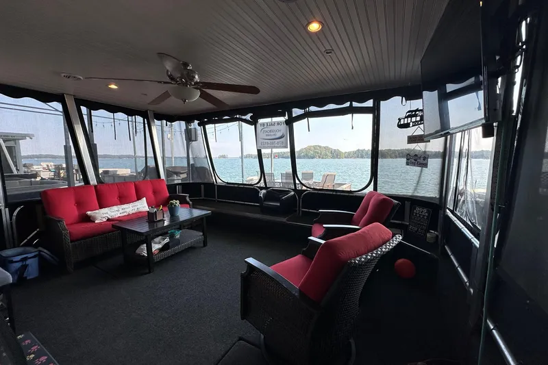Slide: The Image of Enclosed patio on 2005 Starlite 16x82 houseboat with lake view and red seating. - 2