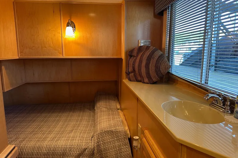 Slide: The Image of Cozy 2005 Starlite 16x82 cabin interior with bed, sink, and window blinds. - 9