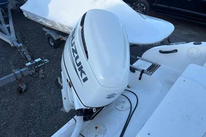 Slide: The Image of 2002 Seaswirl Striper 2301 Walkaround with Suzuki outboard motor, parked on trailer. - 10