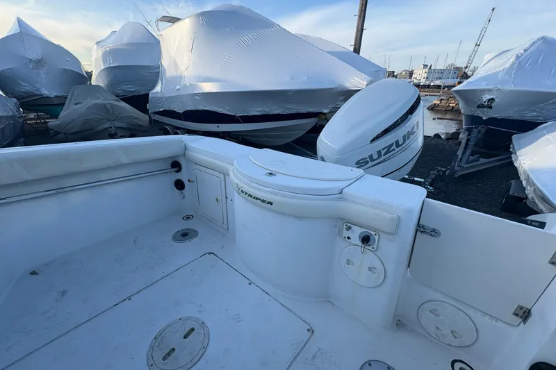 Slide: The Image of 2002 Seaswirl Striper 2301 Walkaround O/B with Suzuki outboard, docked and covered. - 11