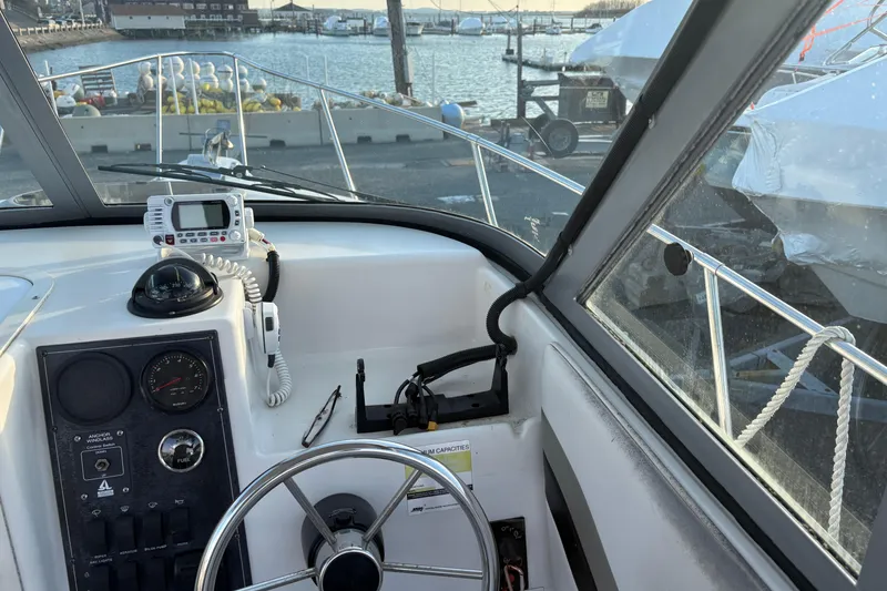 Slide: The Image of 2002 Seaswirl Striper 2301 Walkaround O/B helm with gauges and marina view. - 15