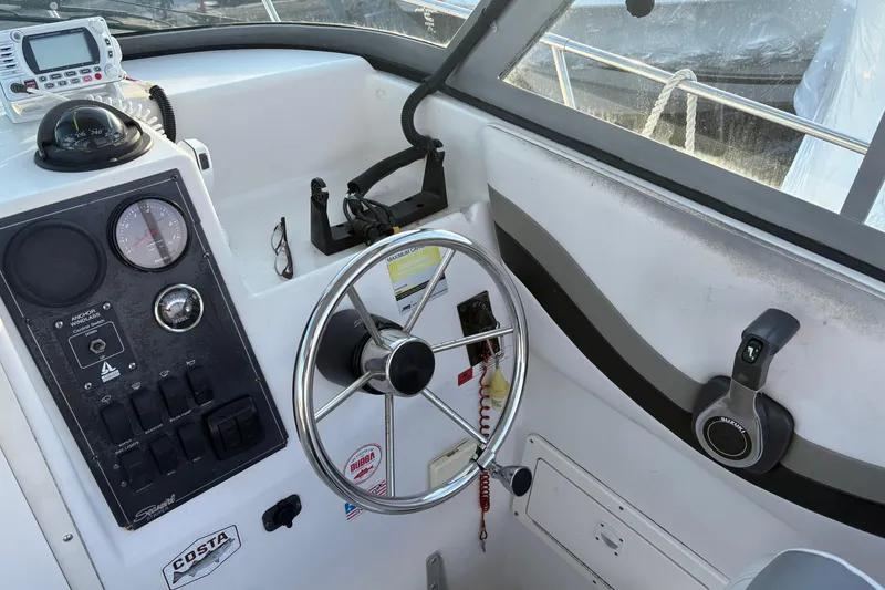 Slide: The Image of 2002 Seaswirl Striper 2301 Walkaround O/B helm with steering wheel and control panel. - 16