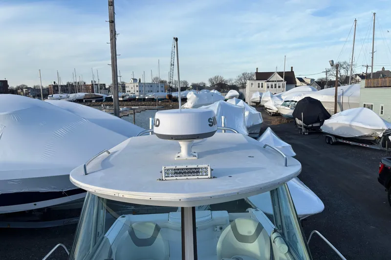 Slide: The Image of 2002 Seaswirl Striper 2301 Walkaround O/B in a marina with covered boats. - 5