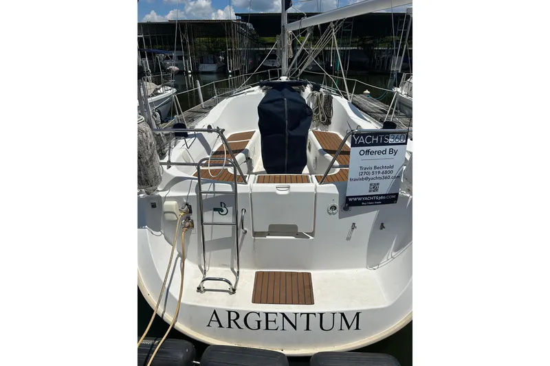 Slide: The Image of 2004 Beneteau Oceanis Clipper 331 sailboat docked, rear view with "ARGENTUM" name. - 27
