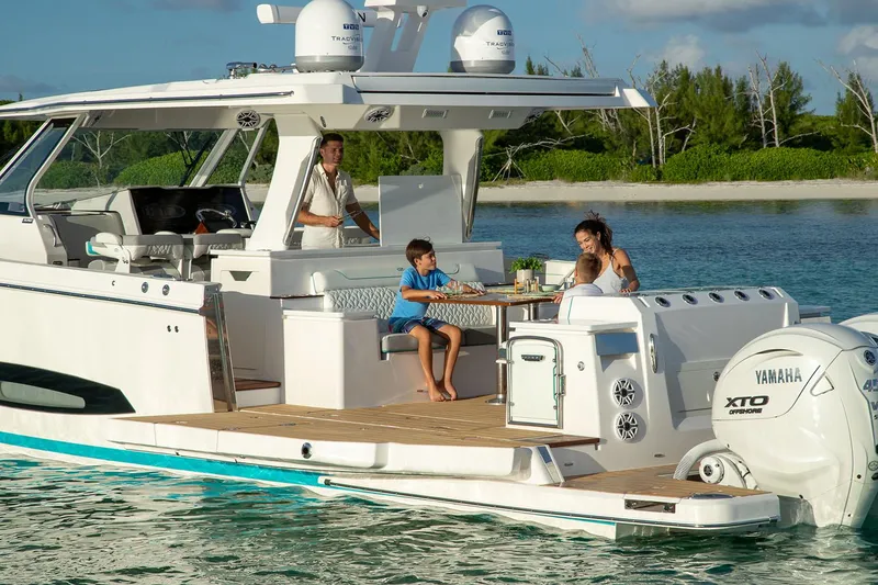 The Image of Manufacturer Provided Image: Family enjoying leisure time on a 2026 Regal 43 SAV boat near a scenic shoreline. - 0