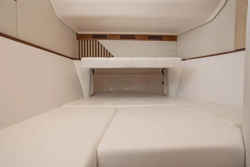 Slide: The Image of Manufacturer Provided Image: Interior cabin of 2026 Regal 43 SAV boat with white cushioned seating. - 12