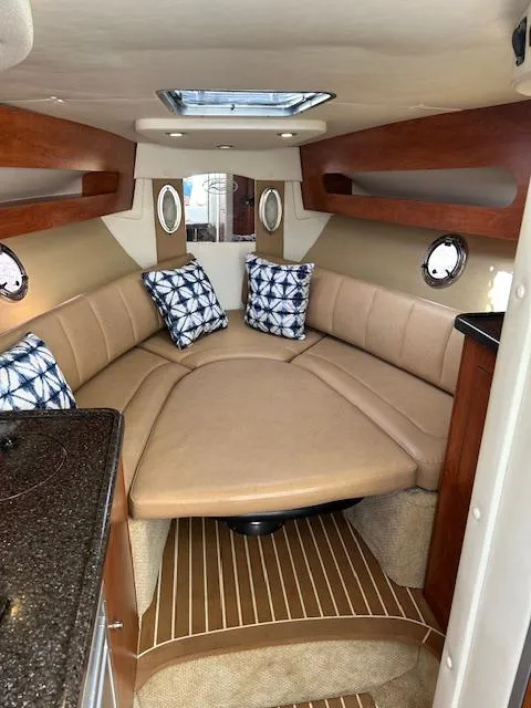 Slide: The Image of Interior of 2013 Rinker 290 Express Cruiser with cozy seating and nautical decor. - 19