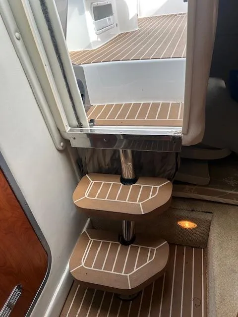 Slide: The Image of Staircase inside 2013 Rinker 290 Express Cruiser with wood-patterned steps. - 22