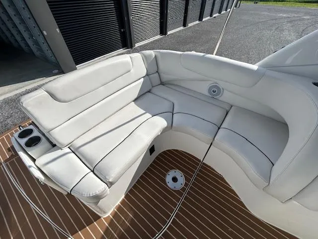 Slide: The Image of 2013 Rinker 290 Express Cruiser interior with white seating and wood flooring. - 47
