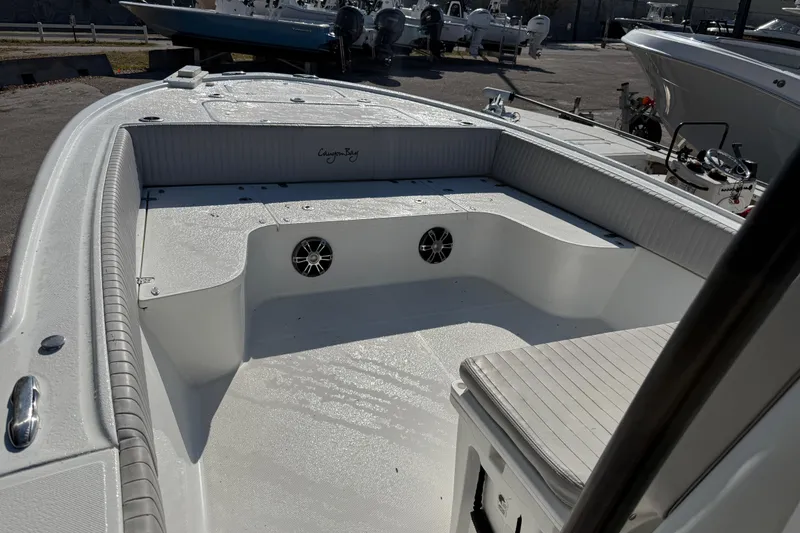 Slide: The Image of 2022 Canyon Bay 28h boat interior with seating and speakers, docked outdoors. - 3