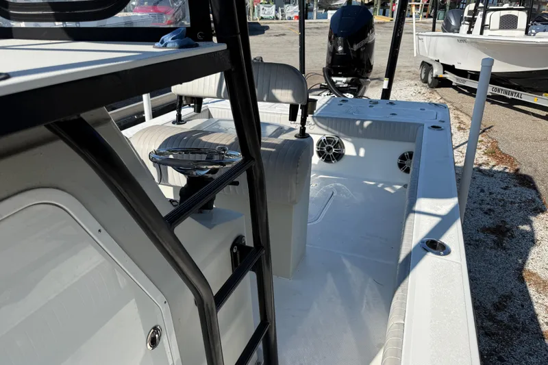 Slide: The Image of 2022 Canyon Bay 28h boat interior with seating and steering wheel, docked outdoors. - 6