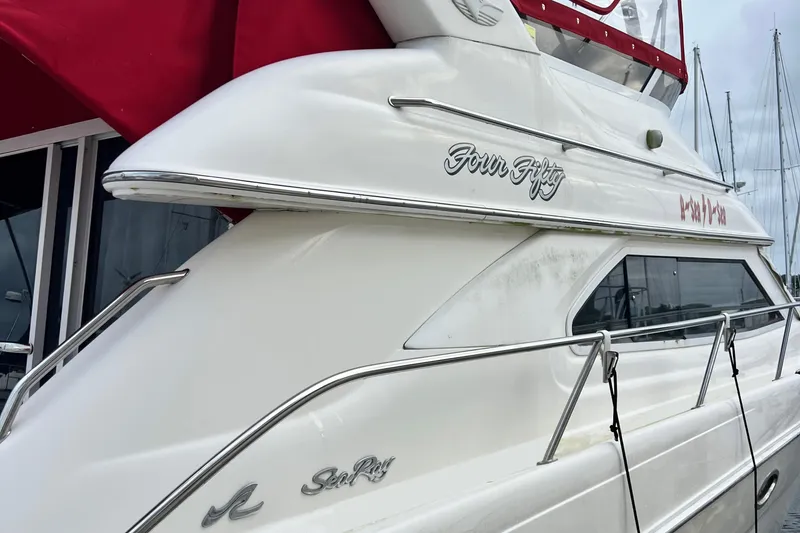 The Image of 2000 Sea Ray 450 Express Bridge yacht docked, featuring sleek white design and chrome accents. - 0