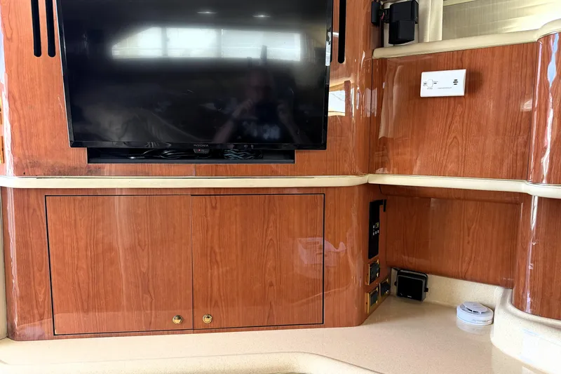 Slide: The Image of Interior of 2000 Sea Ray 450 Express Bridge with TV and wooden cabinetry. - 14