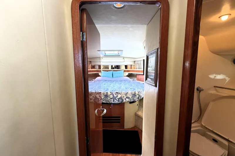 Slide: The Image of Interior cabin view of a 2000 Sea Ray 450 Express Bridge yacht, featuring a cozy bed. - 17