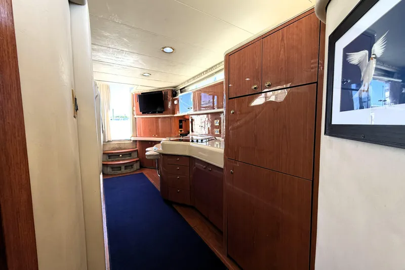 Slide: The Image of Luxurious interior of 2000 Sea Ray 450 Express Bridge yacht with plush seating and table. - 27