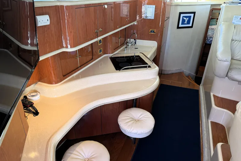 Slide: The Image of Luxurious interior of 2000 Sea Ray 450 Express Bridge yacht with modern kitchen amenities. - 29