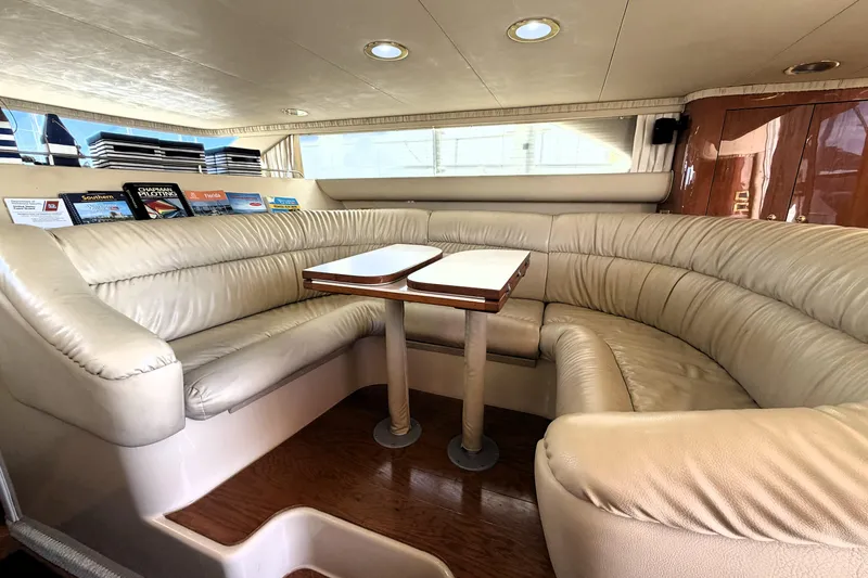 Slide: The Image of Luxurious interior of 2000 Sea Ray 450 Express Bridge with plush seating and wooden table. - 3