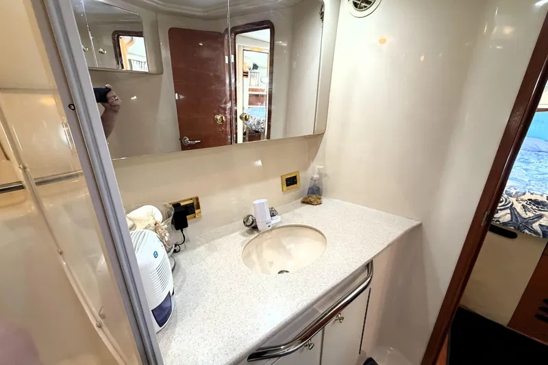 Slide: The Image of Bathroom interior of 2000 Sea Ray 450 Express Bridge yacht, featuring a sleek countertop and mirror. - 34