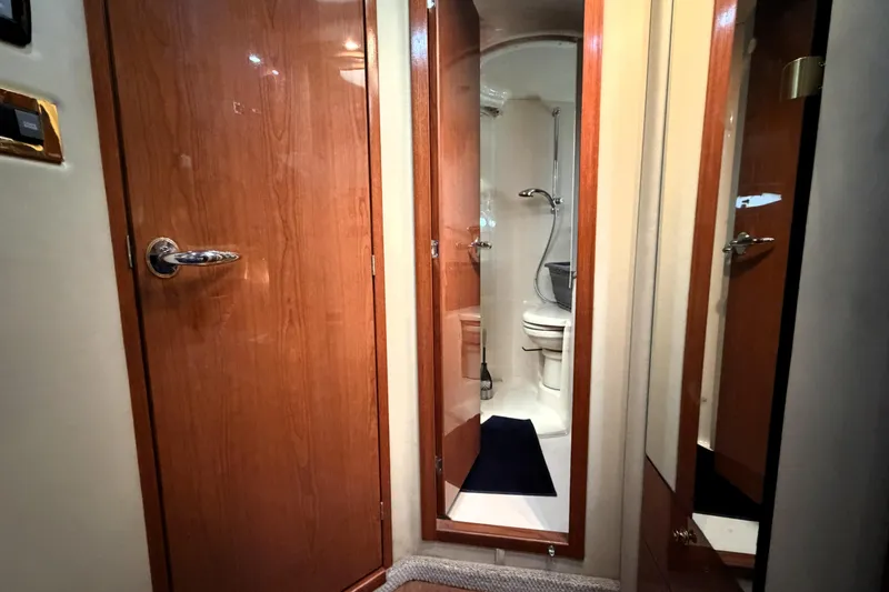 Slide: The Image of Interior of 2000 Sea Ray 450 Express Bridge showing bathroom with wooden doors and fixtures. - 43