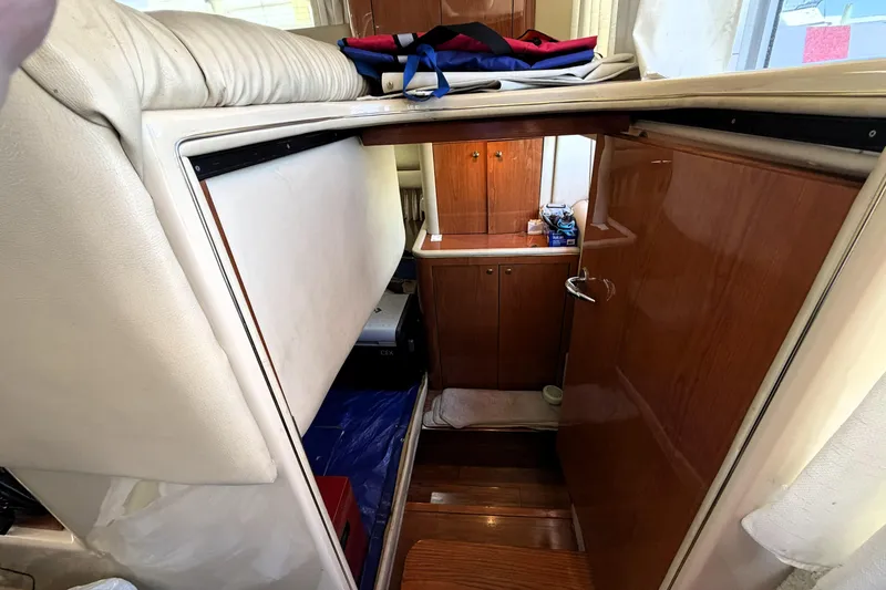 Slide: The Image of Interior view of 2000 Sea Ray 450 Express Bridge, featuring wooden cabinetry and seating. - 44