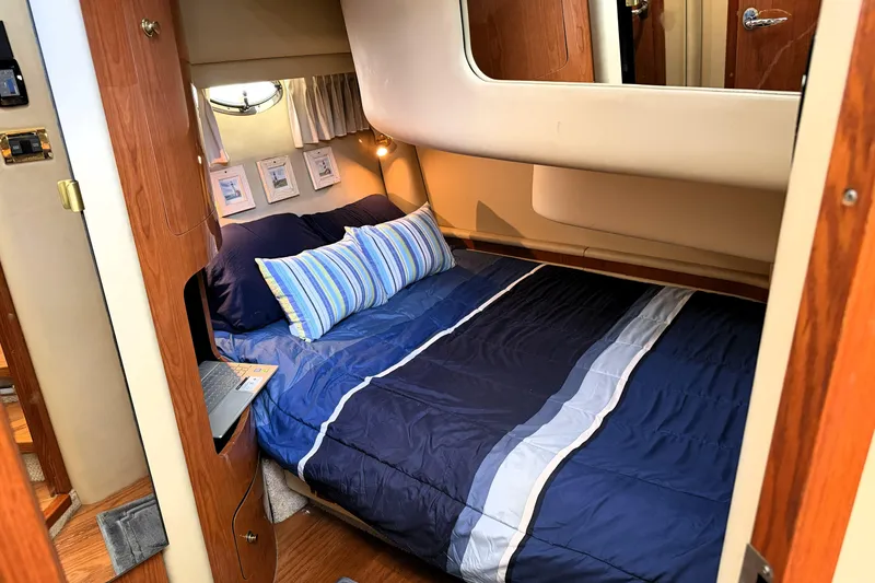 Slide: The Image of Cozy bedroom interior of 2000 Sea Ray 450 Express Bridge yacht with blue bedding. - 45