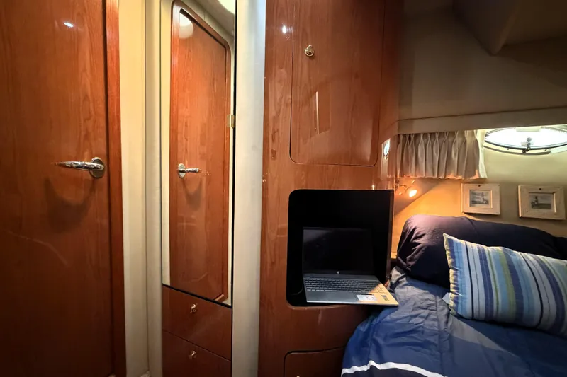 Slide: The Image of Interior of 2000 Sea Ray 450 Express Bridge with wood cabinetry and cozy sleeping area. - 48