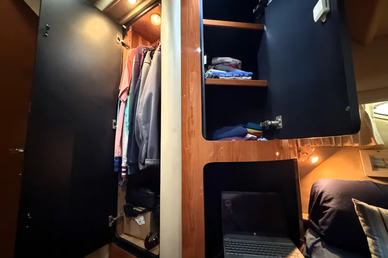 Slide: The Image of Interior of 2000 Sea Ray 450 Express Bridge with open closets and laptop. - 49