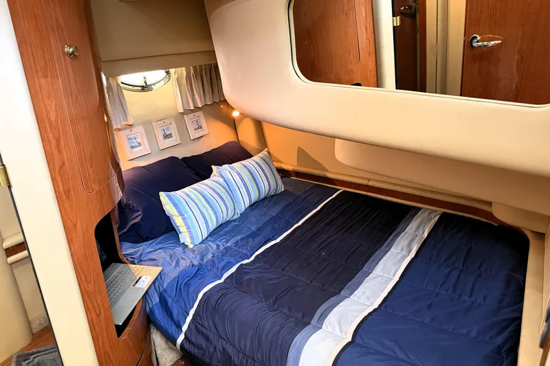 Slide: The Image of Cozy bedroom interior of 2000 Sea Ray 450 Express Bridge yacht with blue bedding. - 51