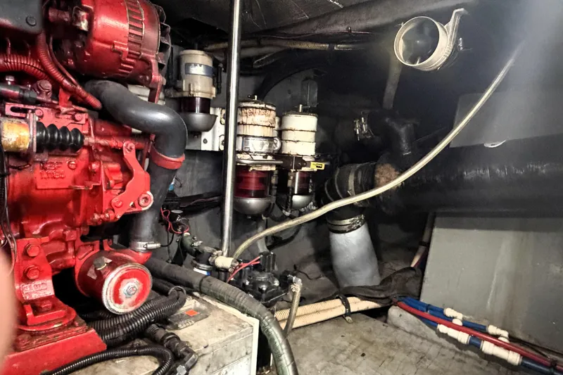 Slide: The Image of Engine room of 2000 Sea Ray 450 Express Bridge with visible red machinery components. - 58