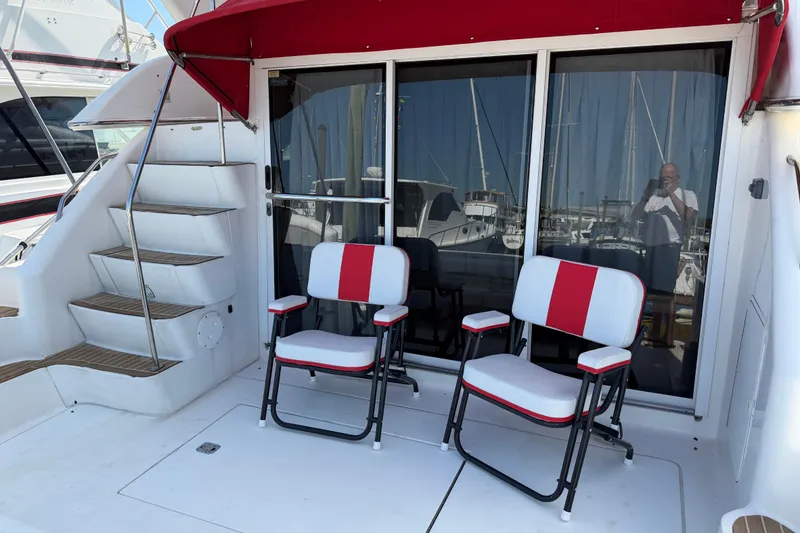 Slide: The Image of Interior of 2000 Sea Ray 450 Express Bridge with open closets and laptop. - 69