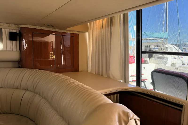 Slide: The Image of Interior of 2000 Sea Ray 450 Express Bridge with leather seating and wooden cabinetry. - 8