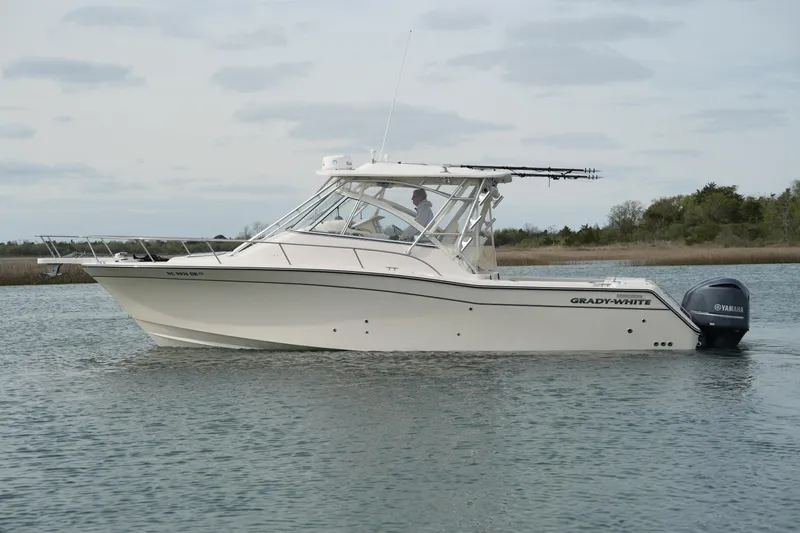 Slide: The Image of 2009 Grady-White Express 330 boat on calm water, featuring Yamaha outboard engines. - 12