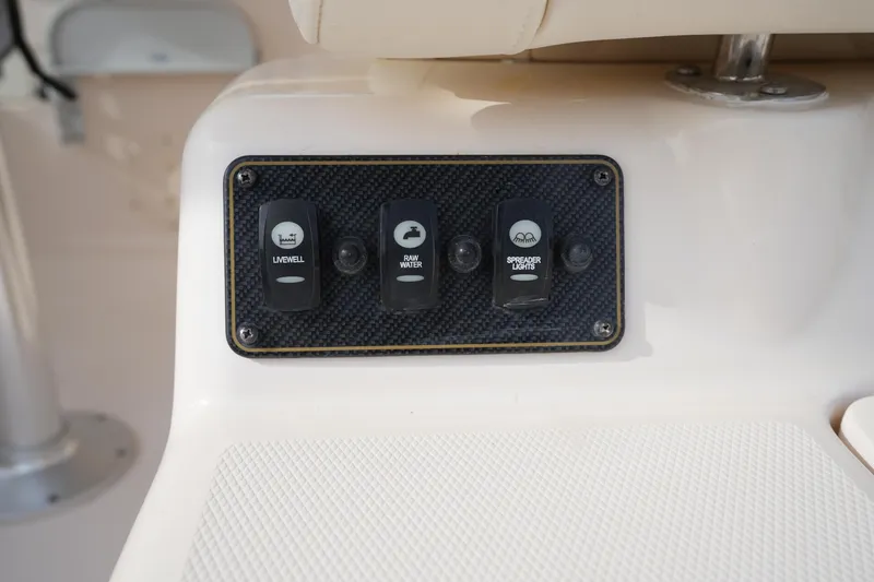 Slide: The Image of Control panel on 2009 Grady-White Express 330 boat with switches for livewell, raw water, and spreader lights. - 23