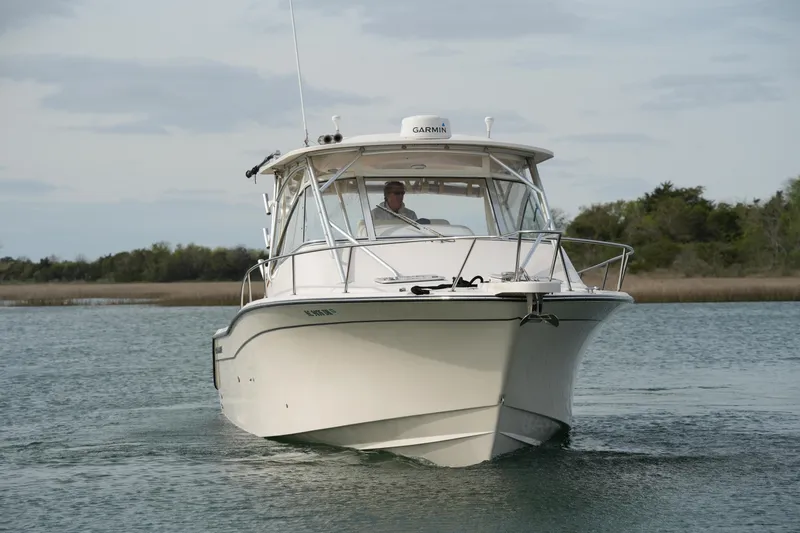Slide: The Image of 2009 Grady-White Express 330 boat cruising on calm water with scenic background. - 3