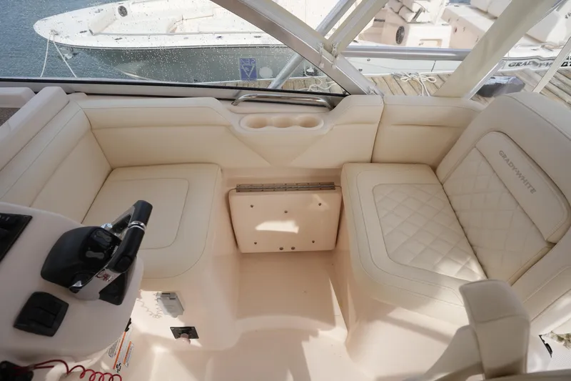 Slide: The Image of 2009 Grady-White Express 330 boat interior with beige seating and steering controls. - 31