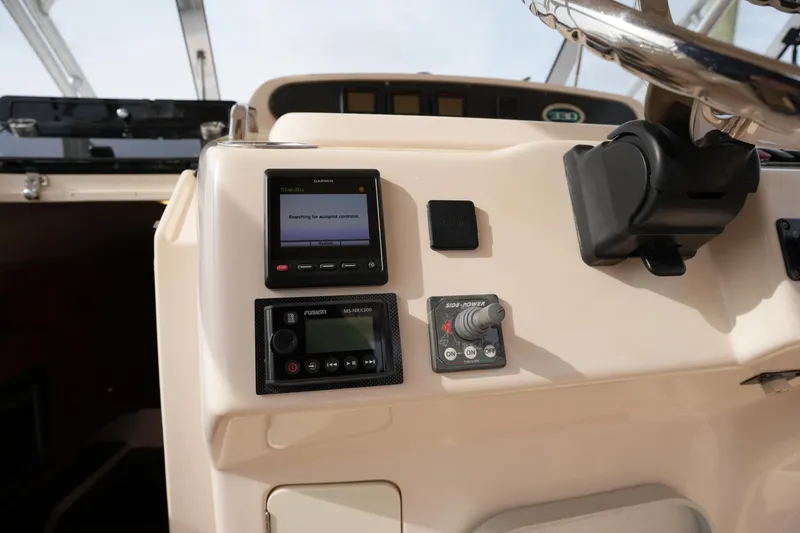 Slide: The Image of 2009 Grady-White Express 330 boat dashboard with Garmin and Fusion controls. - 35