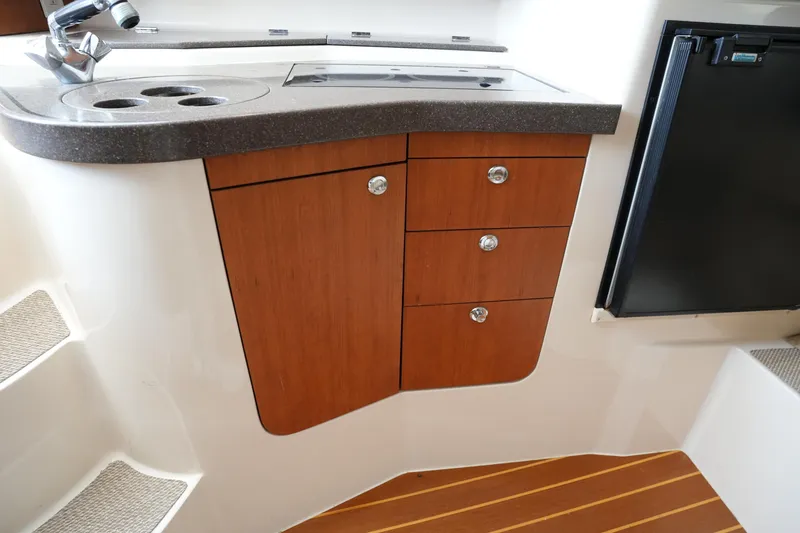 Slide: The Image of 2009 Grady-White Express 330 boat interior with wooden cabinetry and compact kitchenette. - 52
